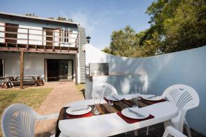 Una mesa blanca y sillas en un patio. en Sedgefield Island Holiday House, en Sedgefield