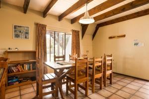 Un comedor con mesa y sillas de madera. en Sedgefield Island Holiday House, en Sedgefield