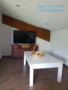 a wicker basket sitting on a white table in front of a tv at Reitanlage Duffner in Horst