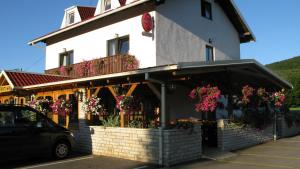 um edifício com flores na frente em Guesthouse Fortuna em Korenica