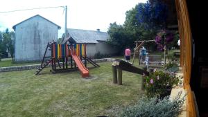 um quintal com um parque infantil com um escorrega em Guesthouse Fortuna em Korenica