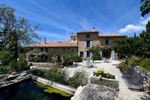 a large house with a pond in front of it at Mas des Olives in Bédoin