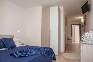 a bedroom with a blue bed and a hallway at Al Faro Guest House in Vieste