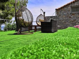 a yard with two swings in the grass at Andreas Village in Vassilias