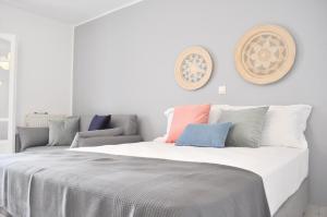 Un dormitorio con una gran cama blanca con almohadas de colores. en Casa Valeri Ι, en Naxos Chora