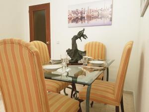 Apartamento turístico en Sevilla في إشبيلية: غرفة طعام مع طاولة وكراسي زجاجية