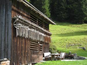 a wooden building with chairs and a table next to it at Ferienhaus Schnetzer in Sankt Gallenkirch