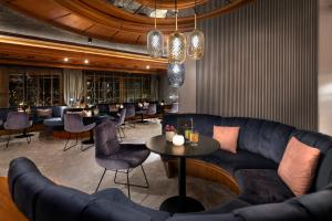 a restaurant with a couch and tables and chairs at Wellness & Genuss Resort - Engel Obertal in Baiersbronn