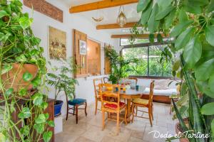 une salle à manger avec une table et de nombreuses plantes dans l'établissement Green house with garden - Dodo et Tartine, à La Valette-du-Var