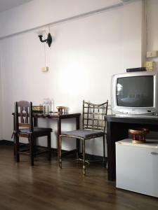 a room with two chairs and a table and a tv at RoongThoeng Place Hotel in Thoeng +29 photos