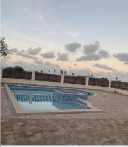 a large swimming pool in front of a building at Nzingha's Villa in Buccoo