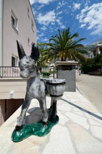 a statue of a dog with a water bowl on a street at Villa Cavar, Apartments Close to the Beach in Makarska