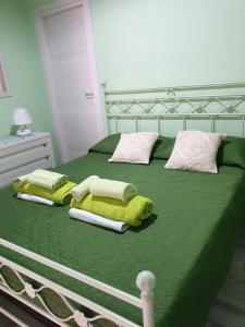 a green bed with towels and pillows on it at El Flamingo Rosa Cod IUN P5386 in Iglesias