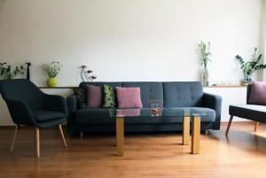 a living room with a blue couch and two chairs at Spacious house at the gate of Giant Mountains in Víchová nad Jizerou