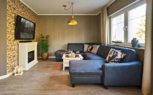 a living room with a blue couch and a fireplace at Freester Kapitänshäuser in Freest