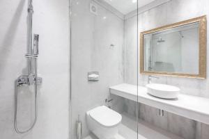 a bathroom with a shower and a toilet and a sink at Saint George Hotel in Chrissi Akti