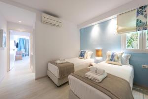 a bedroom with two beds and a couch and a window at Saint George Hotel in Chrissi Akti