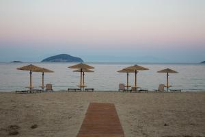 a group of chairs and umbrellas on a beach at Rent House Karavi in Iraklitsa