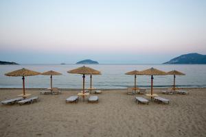 a group of chairs and umbrellas on a beach at Rent House Karavi in Iraklitsa