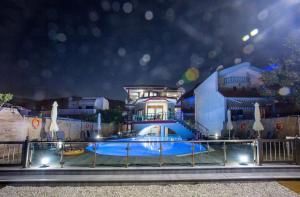 a swimming pool in front of a house at night at Rent House Karavi in Iraklitsa