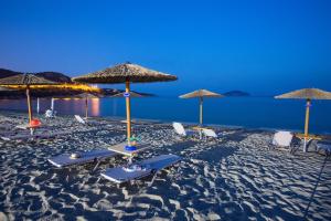 a group of chairs and umbrellas on a beach at Rent House Karavi in Iraklitsa
