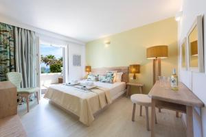 a hotel room with a bed and a table and chairs at Saint George Hotel in Chrissi Akti