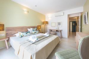 a hotel room with a large bed and a table at Saint George Hotel in Chrissi Akti