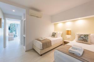 a hotel room with two beds and a hallway at Saint George Hotel in Chrissi Akti