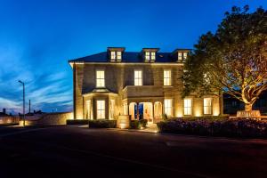 a large brick house with its lights on at Best Luxury Apart Hotel in Oxford- Beechwood House in Oxford