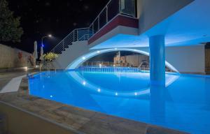 a large swimming pool at night with a staircase at Rent House Karavi in Iraklitsa