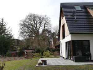 a house with a patio in front of it at Darßer Strandgut - Haus Ahrenshooper Holz in Ahrenshoop