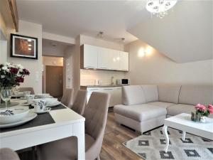een woonkamer met een eettafel en een keuken bij VIP Apartamenty Cristal in Zakopane