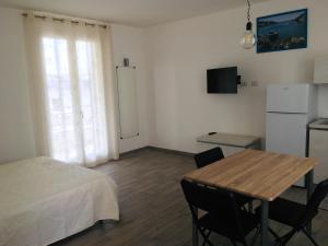 a room with a table and a bed and a refrigerator at aestatisdomus in Uggiano la Chiesa
