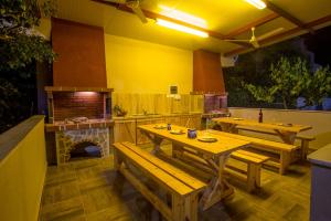 a restaurant with wooden tables and a pizza oven at Rent House Karavi in Iraklitsa