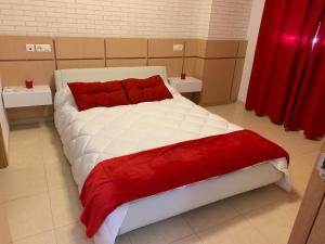 1 cama blanca grande con almohadas rojas en una habitación en Apartamentos Marina Dor Agua Marina en Oropesa del Mar