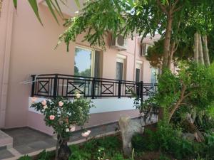 a house with a balcony and a tree at Amazon Studios in Agia Marina Nea Kydonias
