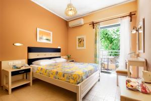 a bedroom with a bed and a desk and a window at Rea Hotel in Palaiochora