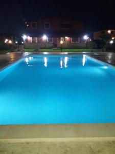 a large blue swimming pool at night at Villa Stefy apartments in Avola