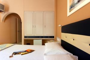 a bedroom with a bed and a cabinet at Rea Hotel in Palaiochora