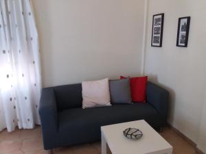 a living room with a blue couch and a table at Amazon Studios in Agia Marina Nea Kydonias