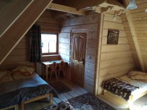 Habitación con 2 camas en una cabaña de madera en Szałas Pasternik en Ciche Małe