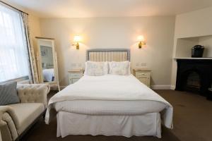 a bedroom with a large bed and a couch at The Old Fourpenny Hotel in Warwick