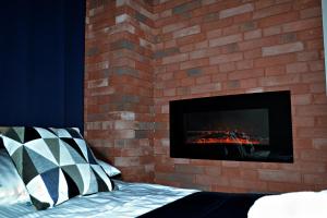 a brick wall with a fireplace in a bedroom at Apartament Uśmiech in Ustrzyki Dolne