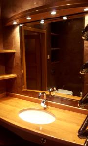 uma casa de banho com um lavatório e um espelho grande em Studio 1 em Varósvia