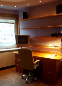um escritório com uma secretária, uma cadeira e um monitor em Studio 1 em Varósvia