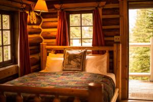 a bedroom with a bed in a log cabin at Storm Mountain Lodge & Cabins in Banff