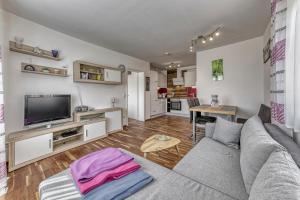 a living room with a couch and a tv at Ferienwohnung Fernblick in Neukirchen vorm Wald