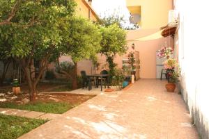 a courtyard of a house with a table and trees at La casa dei nonni in Iglesias