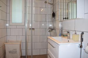 a white bathroom with a shower and a sink at Skogsbacka Torp in Tammisaari +33 photos