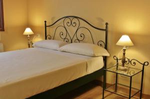 a bedroom with a large bed with two lamps at Agriturismo Cavrigo in Lodi